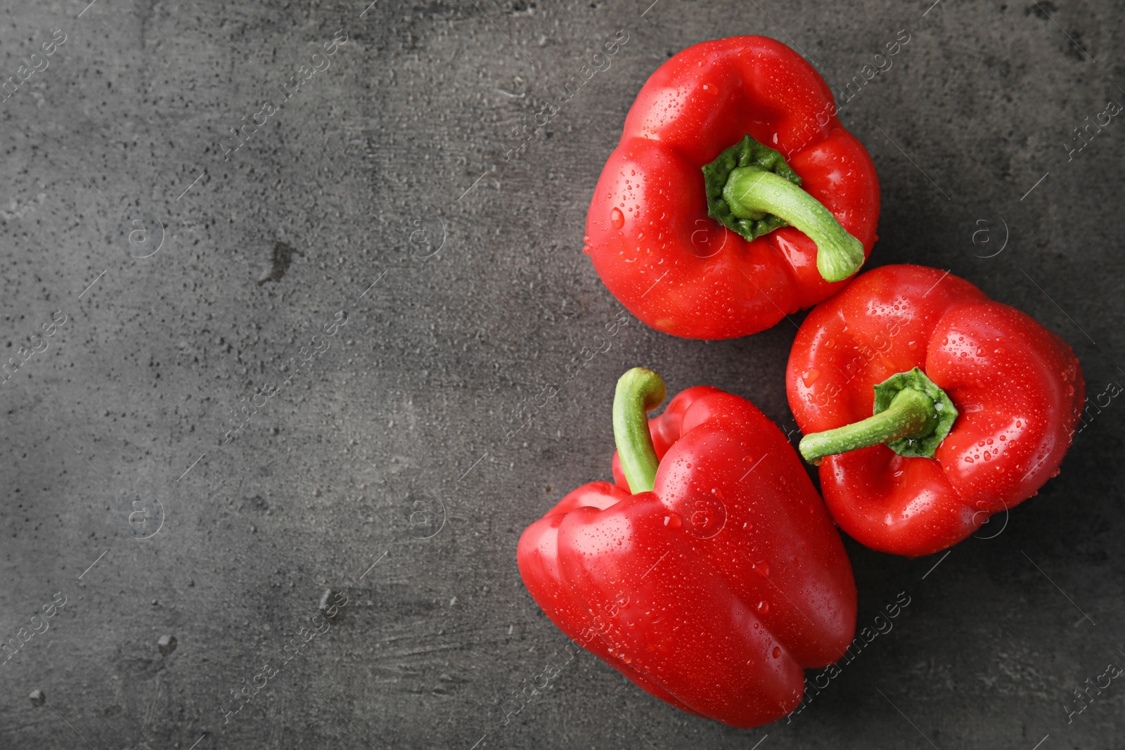 Photo of Raw ripe paprika peppers on grey background, top view