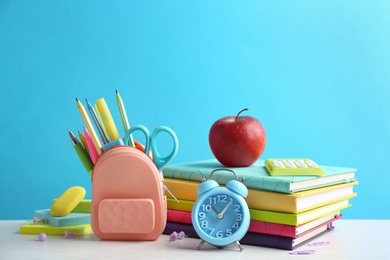 Different school stationery on white table against light blue background