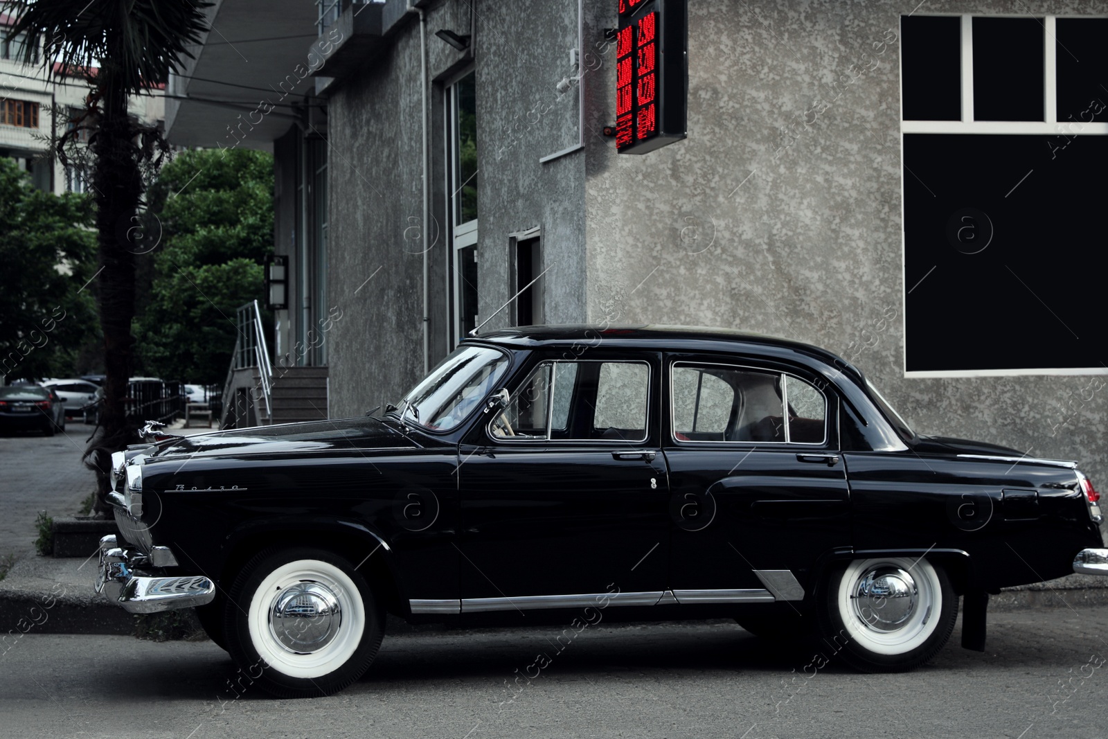 Photo of Beautiful vintage car parked near building on city street