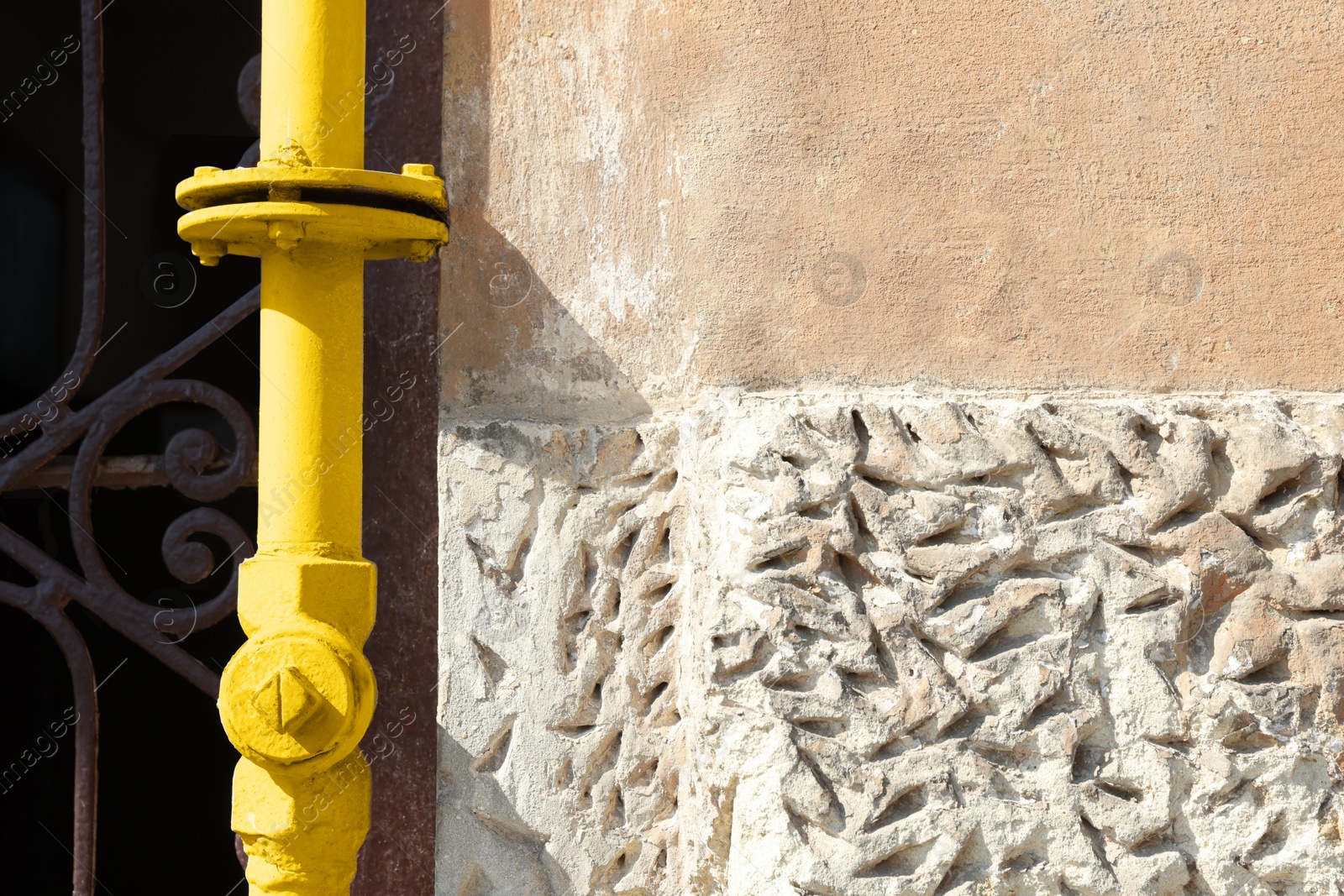 Photo of Yellow gas pipe near old wall outdoors