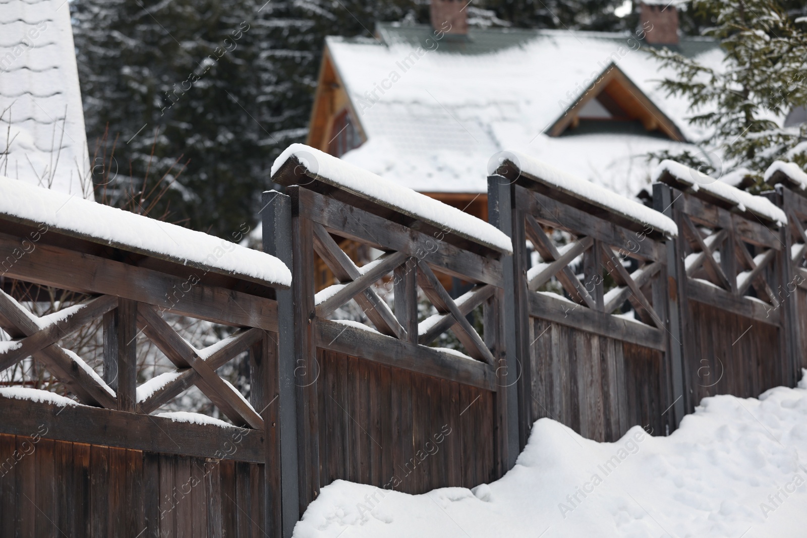 Photo of Wooden fence covered with snow outdoors on winter day