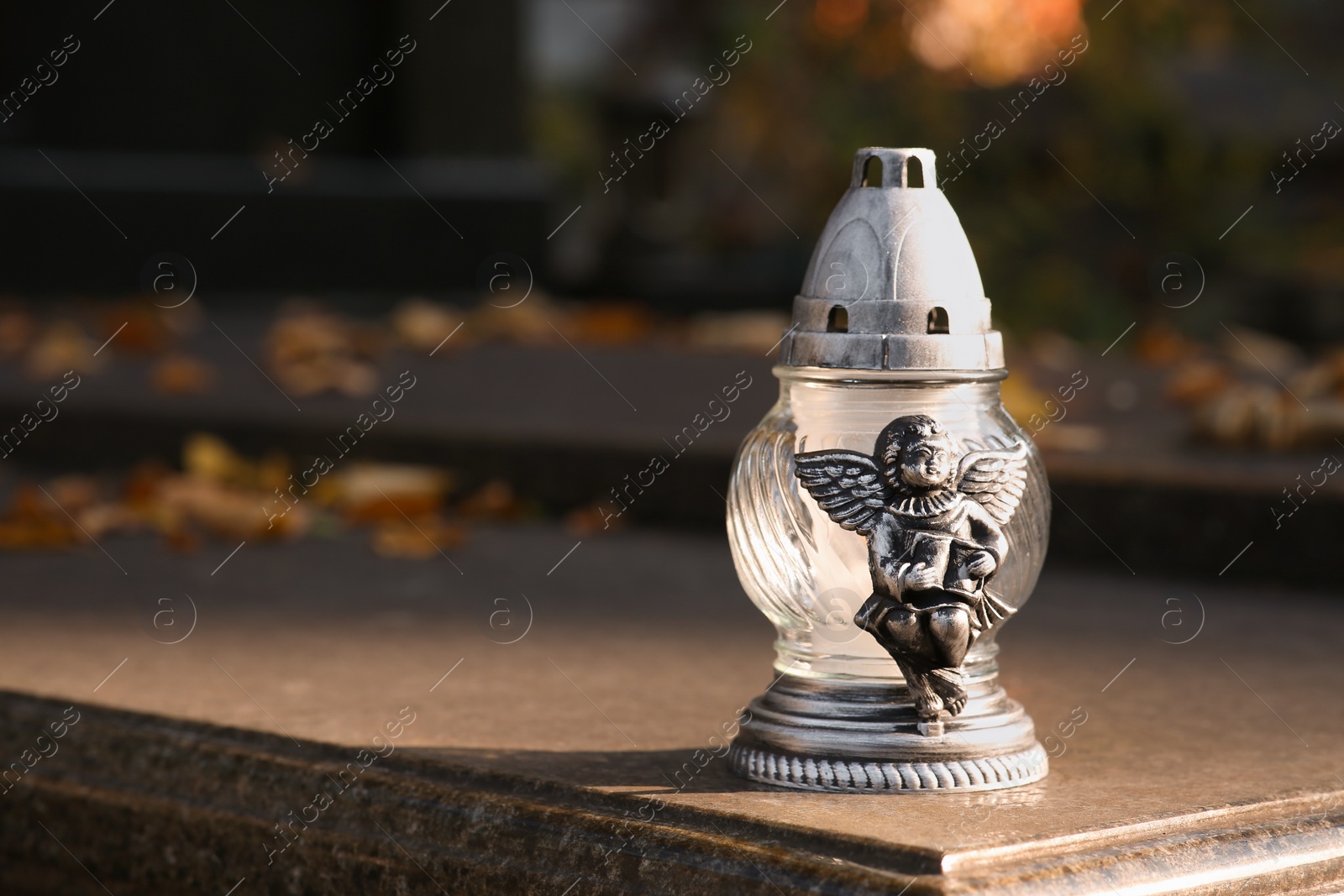 Photo of Grave lantern on granite surface in cemetery, space for text