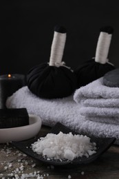 Photo of Spa composition. Sea salt, herbal bags and towels on table