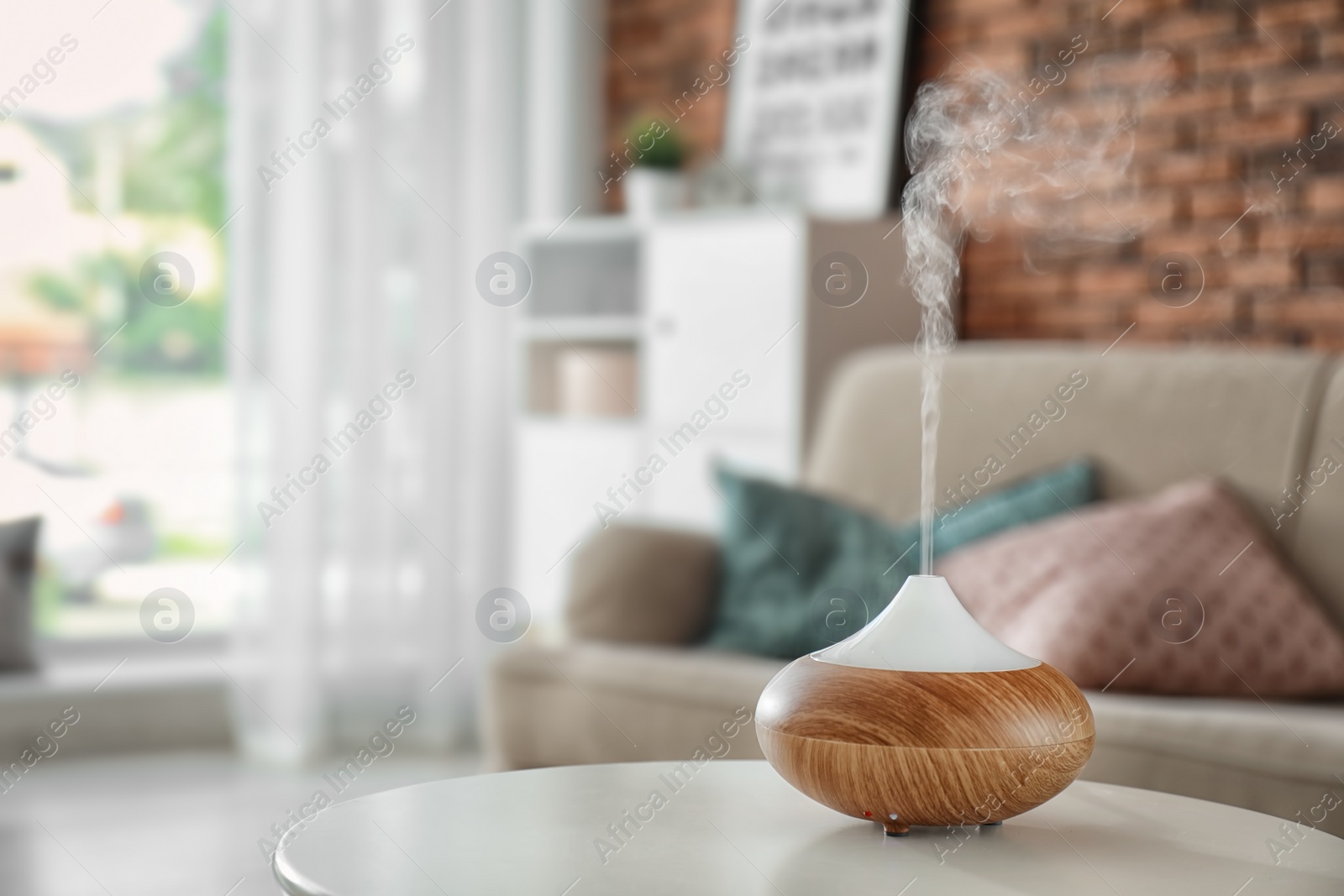 Photo of Aroma oil diffuser on table at home. Air freshener