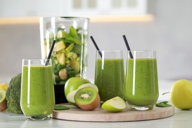 Delicious fresh smoothie and blender with ingredients on white marble table indoors