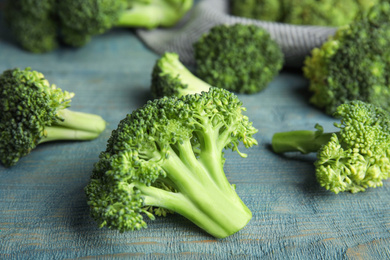 Photo of Fresh green broccoli on blue wooden table, closeup