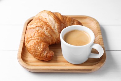 Photo of Fresh croissant and coffee on white wooden table. Tasty breakfast