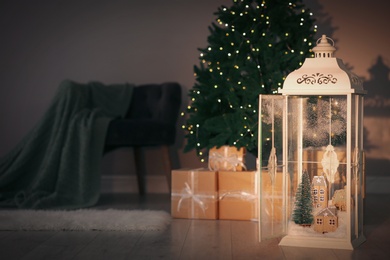 Photo of Vintage wooden lantern with beautiful Christmas composition on floor indoors. Space for text