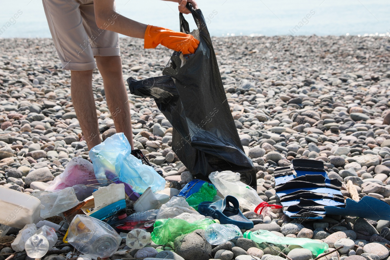 Photo of Man with trash bag collecting garbage in nature, closeup. Environmental Pollution concept