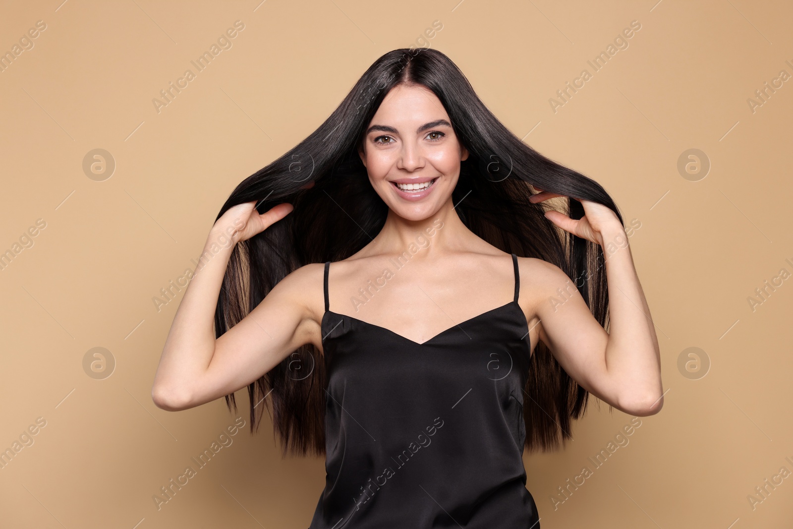 Photo of Portrait of beautiful young woman with healthy strong hair on beige background