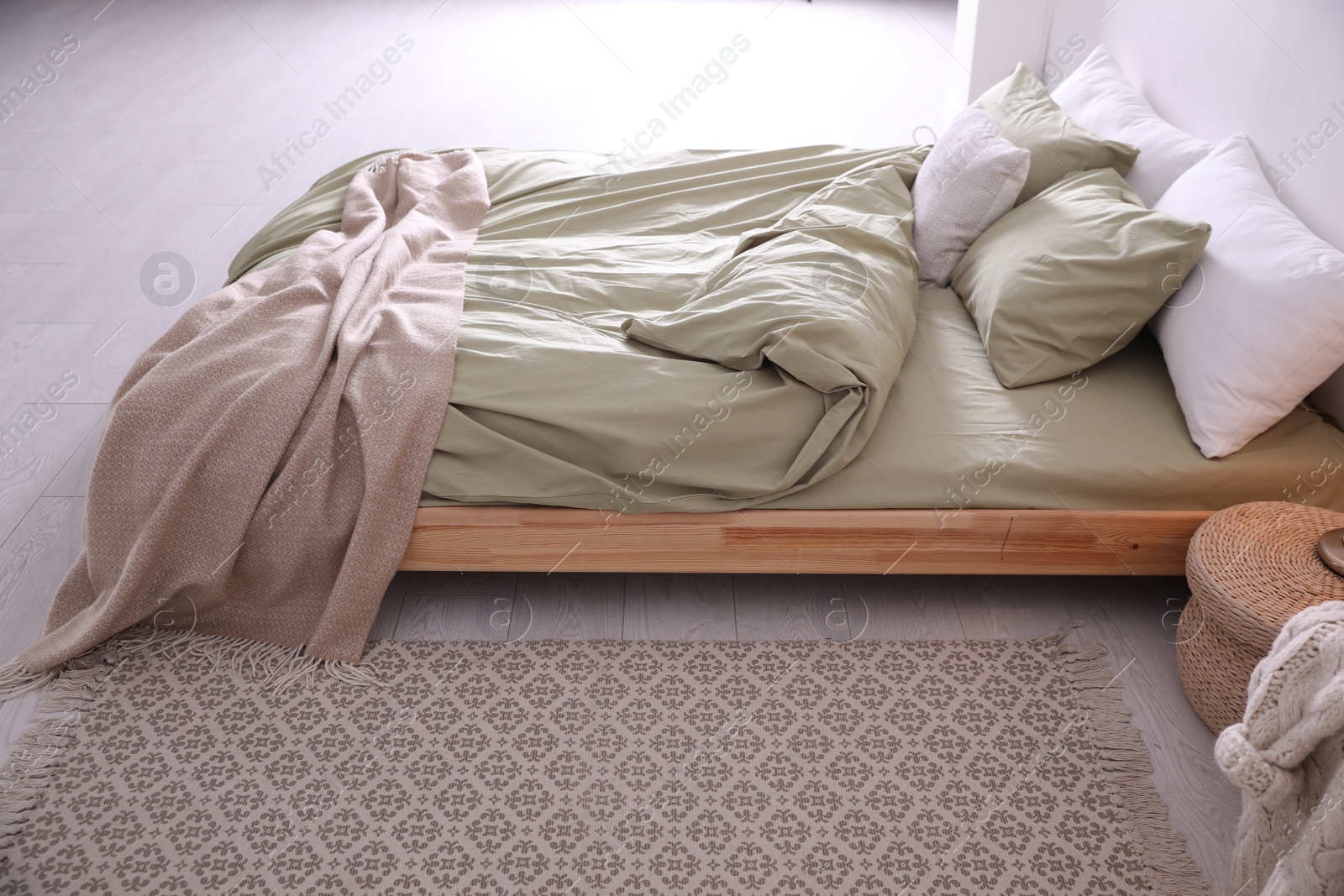 Photo of Comfortable bed with olive green linen in modern room interior