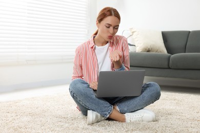 Woman blowing kiss during video chat via laptop at home. Long-distance relationship