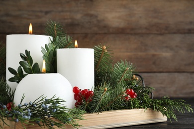 Photo of Beautiful Christmas composition with burning white candles on wooden background