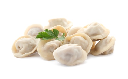 Photo of Pile of boiled dumplings with parsley leaves on white background