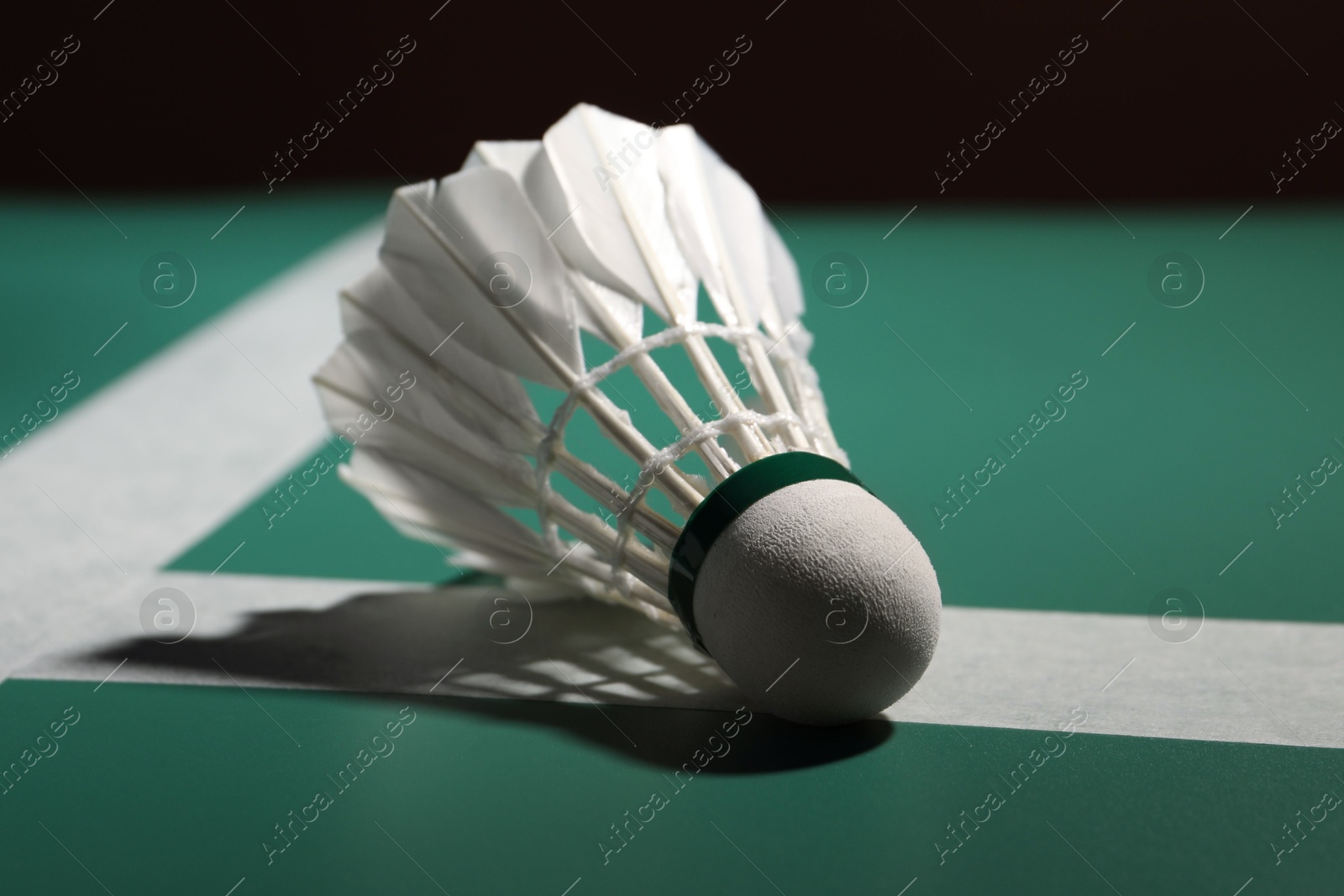 Photo of Feather badminton shuttlecock on green table, closeup