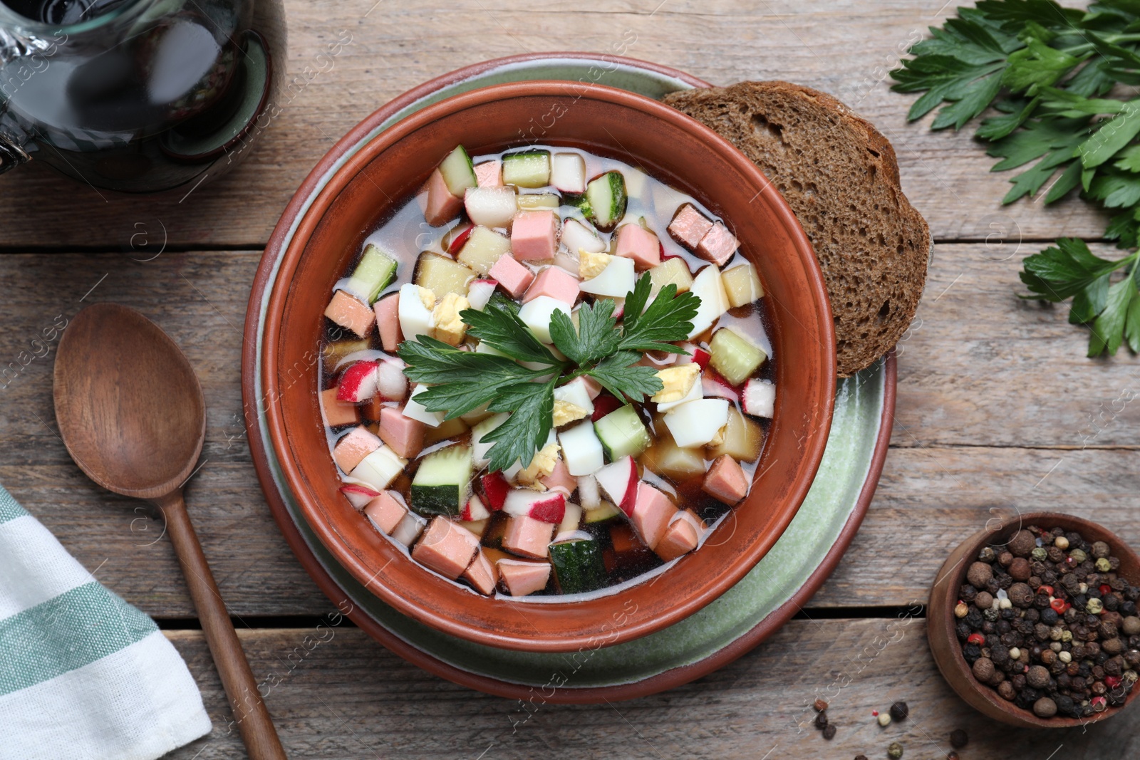 Photo of Delicious cold okroshka with kvass served on wooden table, flat lay. Traditional Russian summer soup