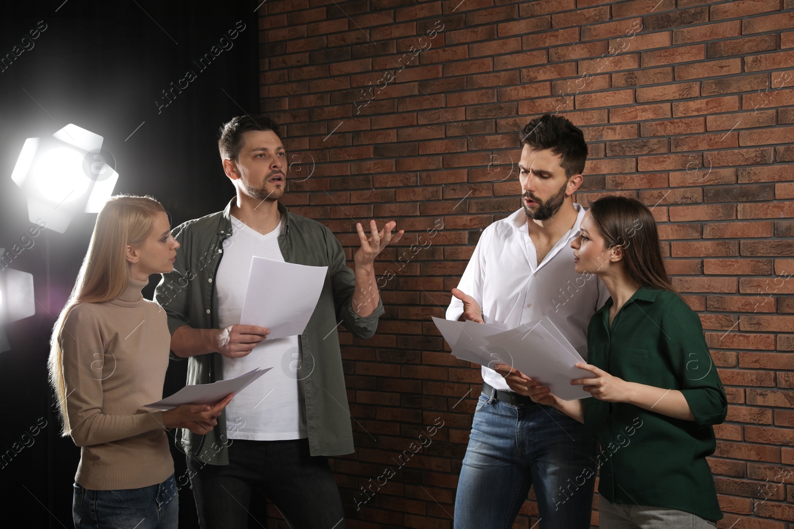 Photo of Professional actors reading their scripts during rehearsal in theatre