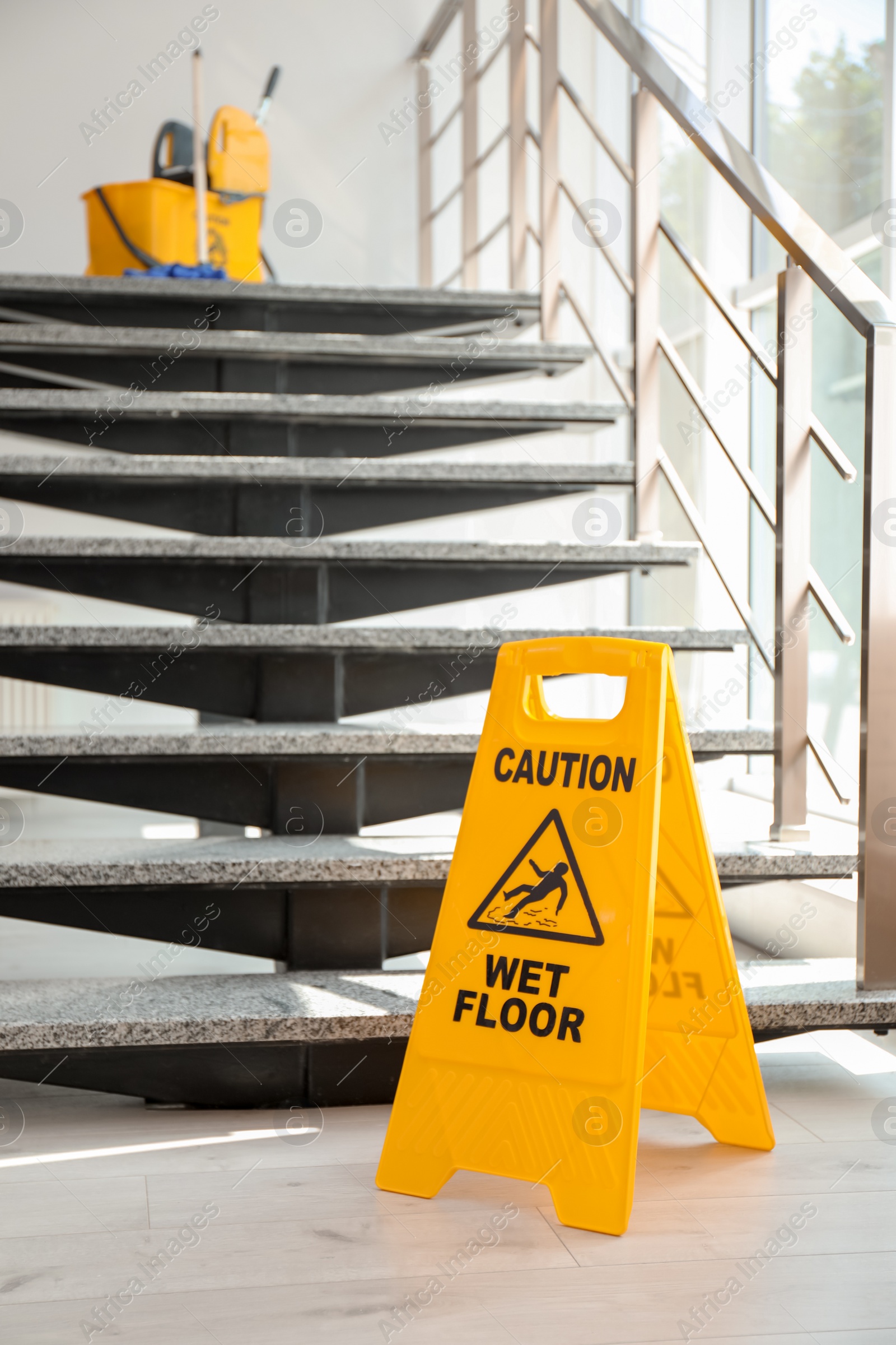 Photo of Safety sign with phrase Caution wet floor near stairs. Cleaning service