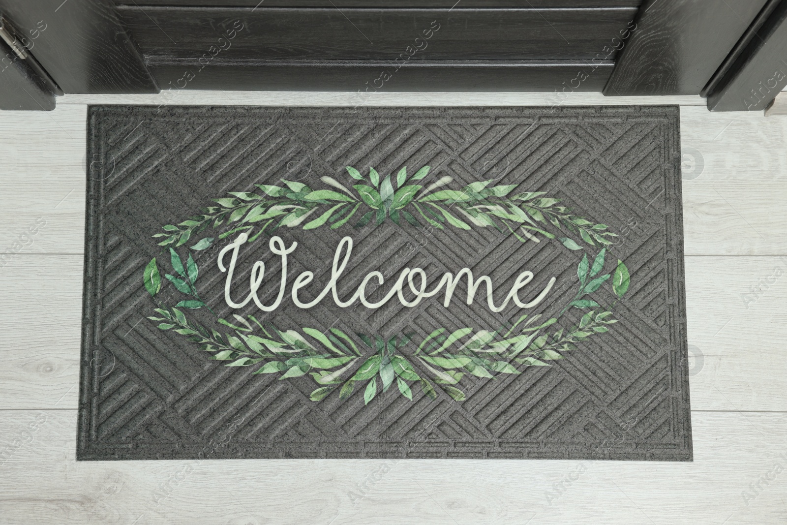 Photo of Doormat with word Welcome on white floor near entrance, top view