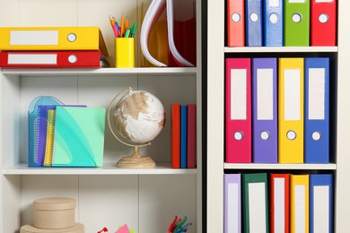 Colorful binder office folders and other stationery on shelving unit