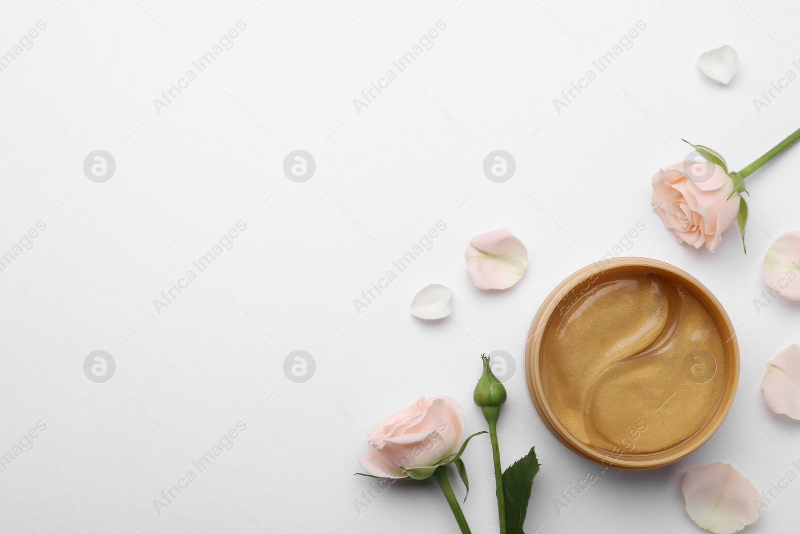 Photo of Under eye patches in jar and rose flowers on white background, flat lay. Space for text