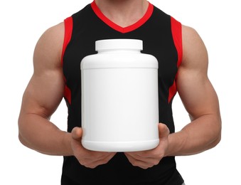 Young man with muscular body holding jar of protein powder on white background, closeup