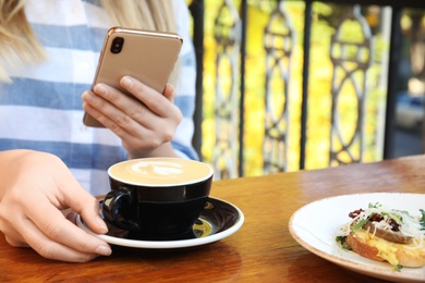 Photo of Food blogger taking photo of her lunch at cafe, closeup