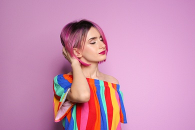 Young woman with trendy hairstyle against color background