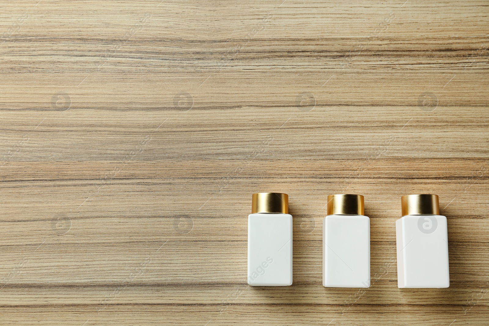 Photo of Cosmetic bottles on wooden table, flat lay with space for text. Spa treatment