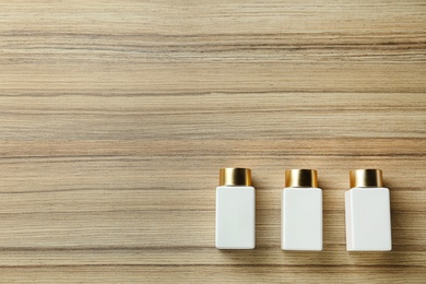 Photo of Cosmetic bottles on wooden table, flat lay with space for text. Spa treatment