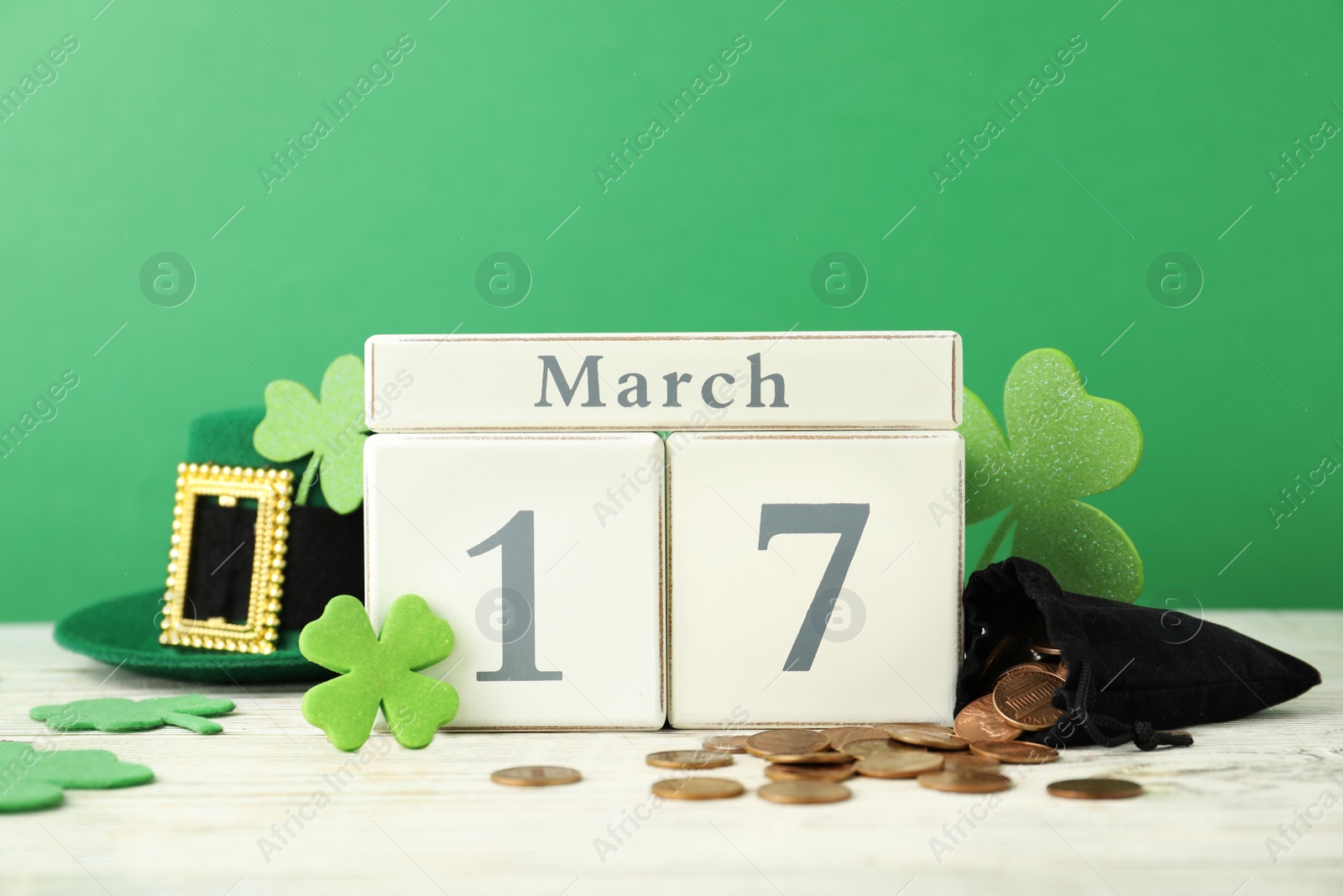 Photo of Composition with block calendar on white wooden table. St. Patrick's Day celebration
