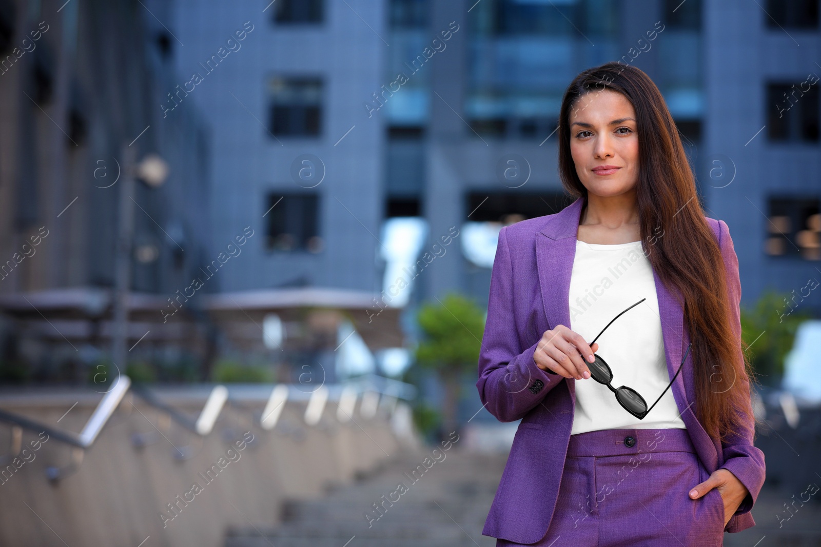 Photo of Beautiful businesswoman with sunglasses on city street. Space for text