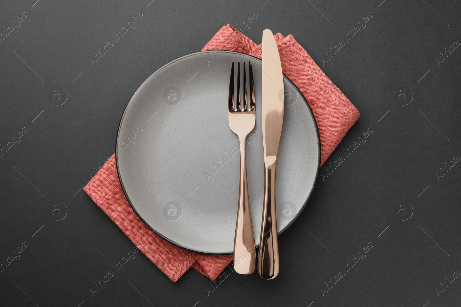 Photo of Clean plate, cutlery and napkin on grey table, top view