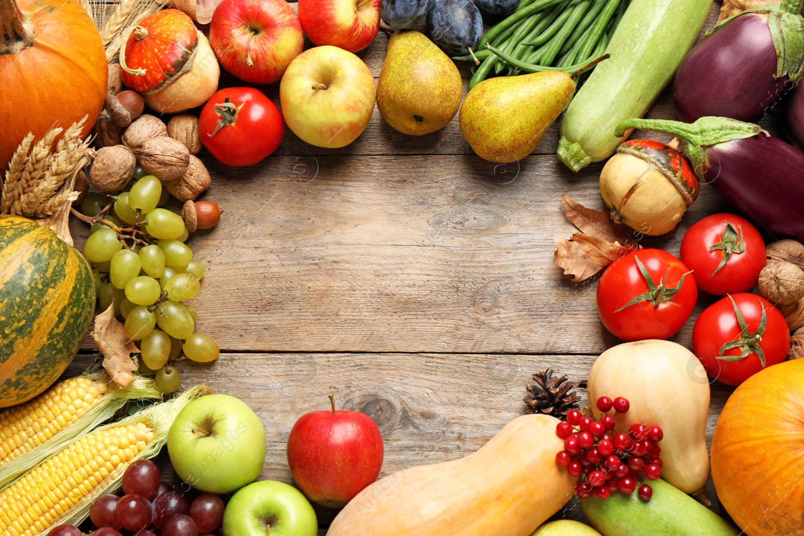 Photo of Frame made of autumn vegetables and fruits on wooden background, top view with space for text. Happy Thanksgiving day