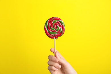 Photo of Woman holding yummy candy on color background