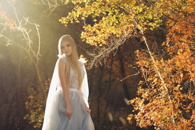 Photo of Beautiful girl wearing fairy dress in autumn forest