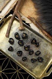 Photo of Many black rune stones on divination mat, flat lay