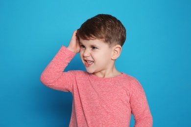 Photo of Little boy scratching head on color background. Annoying itch