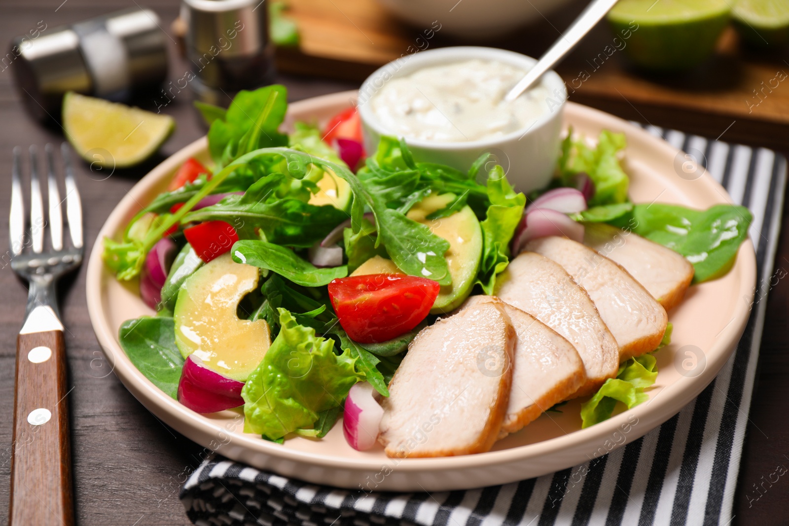 Photo of Delicious salad with chicken, arugula and avocado on wooden table, closeup