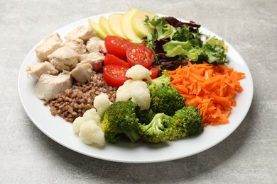 Photo of Balanced diet and healthy foods. Plate with different delicious products on grey table, closeup