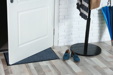 Photo of Hallway interior with mat and clothes stand near door