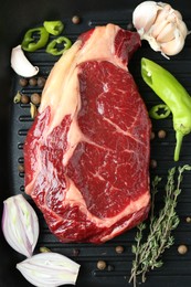 Photo of Piece of fresh beef meat, thyme and spices on grill pan, flat lay