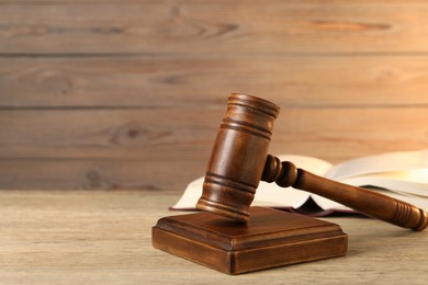 Photo of Wooden gavel and sound block on table, closeup. Space for text