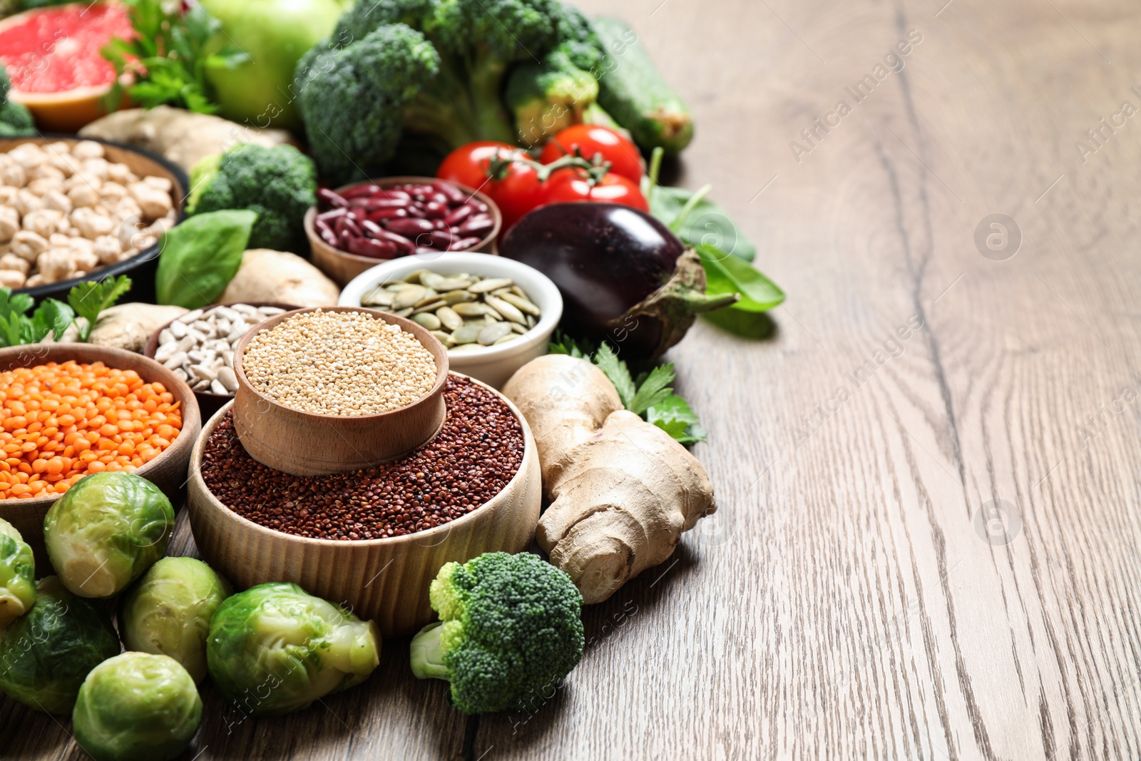 Photo of Fresh vegetables and seeds on wooden table, space for text