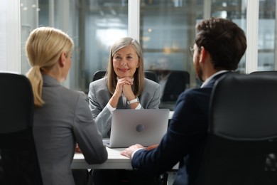 Photo of Lawyer working with clients at table in office