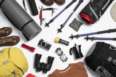 Composition with backpack and other camping equipment for tourism on white background, flat lay