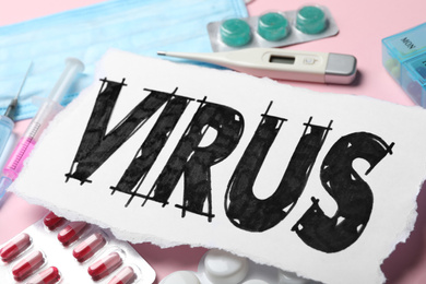 Photo of Word VIRUS and medicines on pink background, closeup