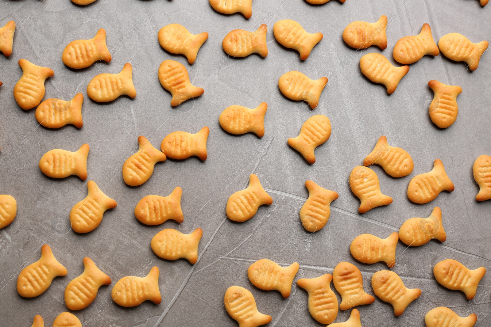Photo of Delicious fish shaped crackers on grey table, flat lay