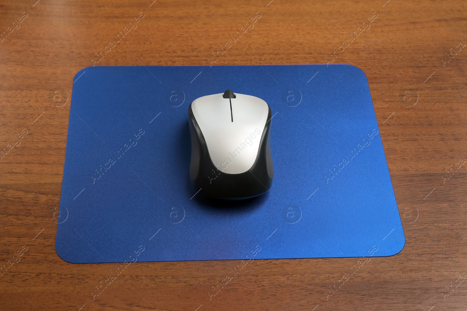 Photo of Blank pad and wireless computer mouse on wooden background