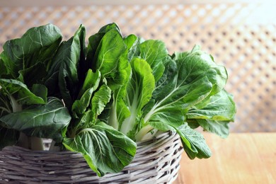 Fresh green pak choy cabbages in wicker basket closeup